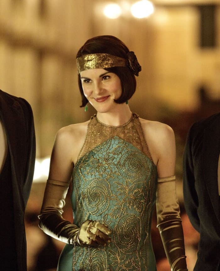 Mary shows up to dinner at the Criterion wearing a stunning bias-cut gown with lace filigree over the bodice.