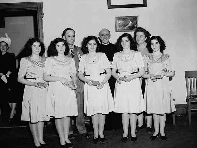 Dionne quintuplets, accompanied by Mrs. Olive Dionne & Frere Gustave Sauve, take part in a program of religious music at Lansdowne park, during the five day Marian Congress which prayed for peace & celebrated the centenary of the Ottawa archdiocese.