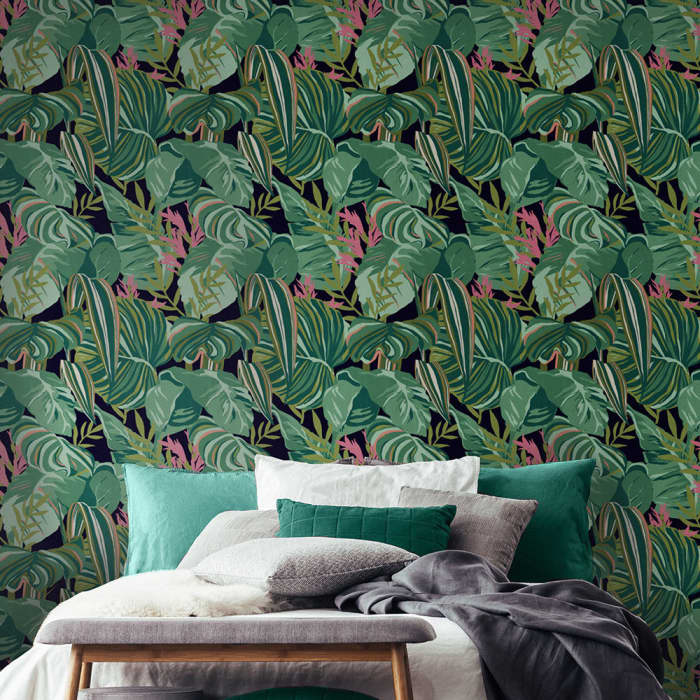 On a dark green backdrop, a beautiful matt digital picture of stylised painterly tropical leaves in shades of green, with pink detail, is suitable for that chic jungle look.