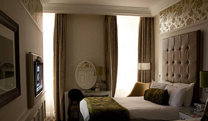 An oversize headboard and soothing paint color are just the touches to transform your bedroom into a chic boutique hotel room.