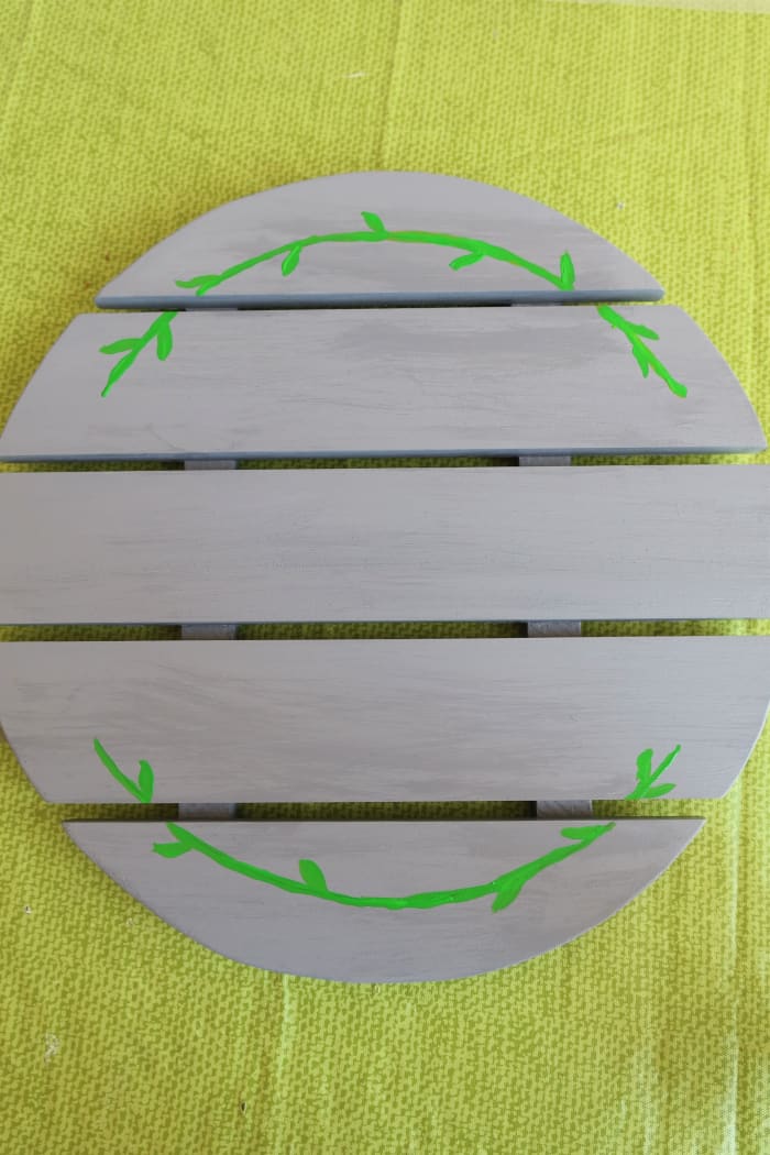 I painted two green curving lines with leaves on the top and bottom of my pallet surface.