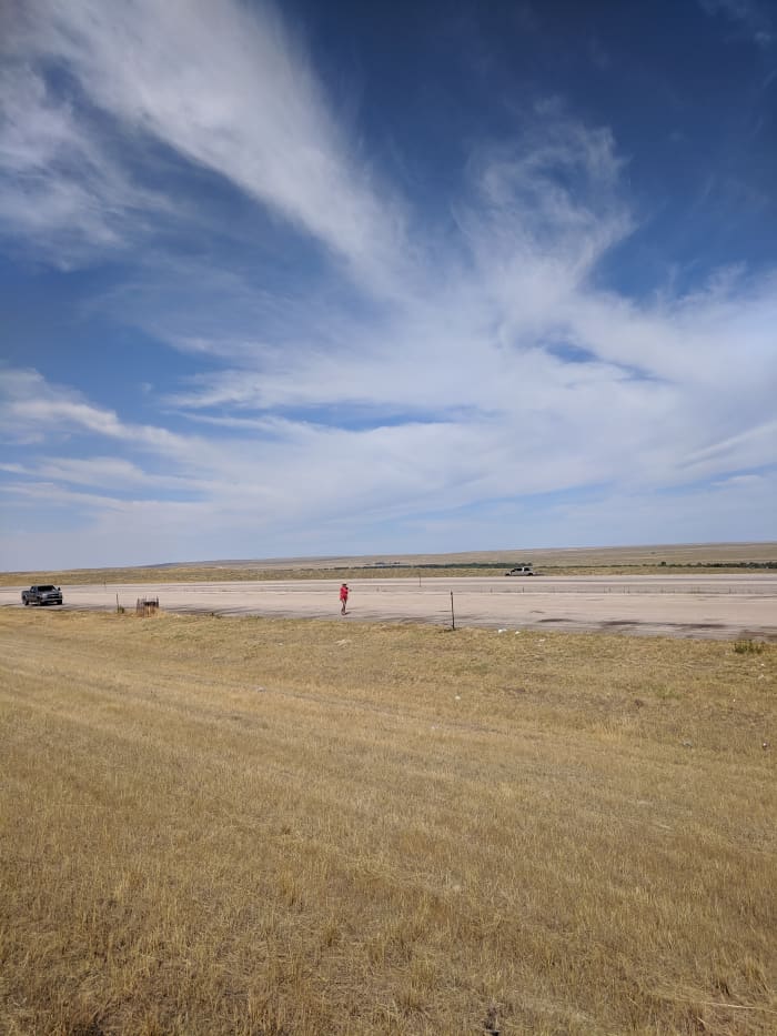 My wife and car dwarfed in the midst of the Great Plains in Wyoming.
