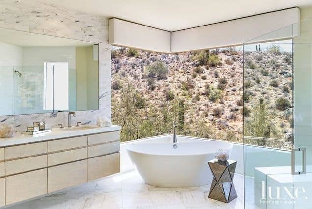 Tumbleweeds rule in the backyard Scottsdale home. The luxury bath has windows overlooking desert hills.