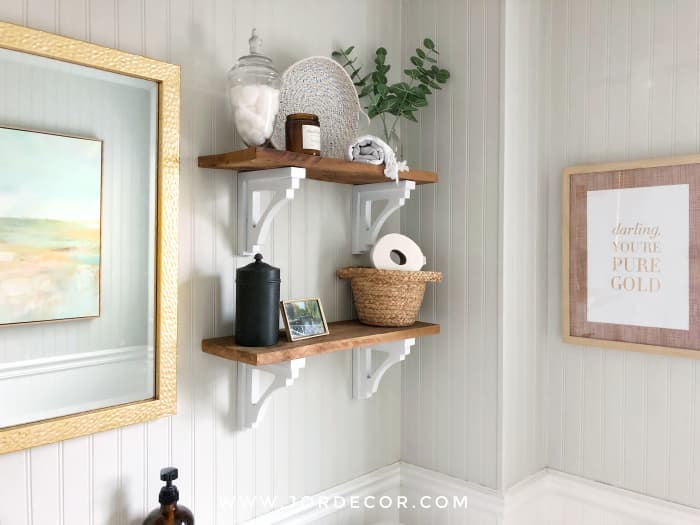 If you've decided on your bathroom wall shelves, style them by combining a few nice things that also serve as storage.