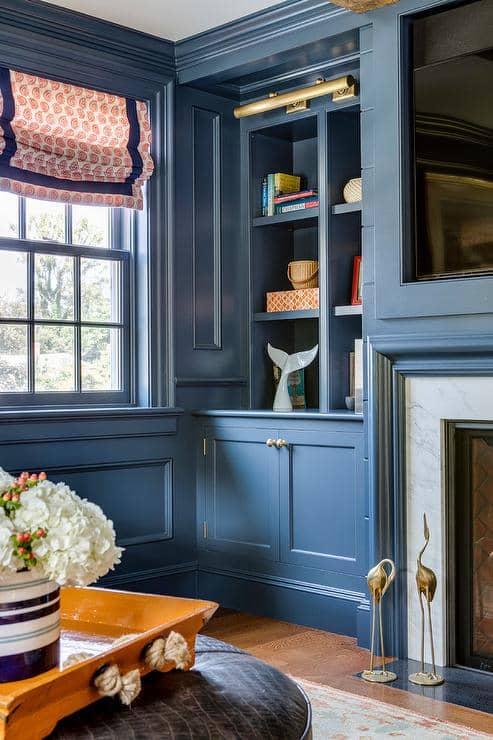 The living room is painted in the same beautiful blue as the rest of the house. The storage-inspired conventional living room blue cabinets and panel walls.