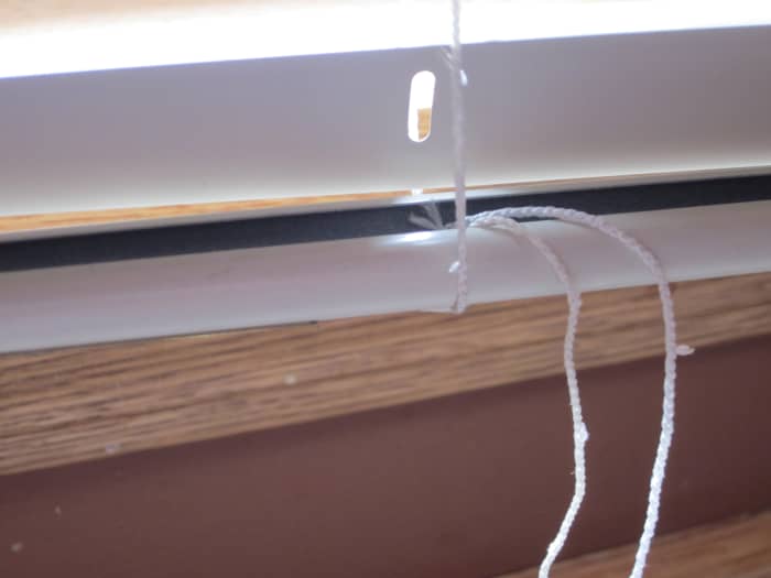 The rungs have been cut, the ladder has been pulled through the hole in the bottom rail and the button replaced