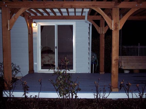 A bedroom window was replaced with a sliding glass door out onto the recycled deck. The addition of a pergola makes it a cozy outdoor "room".