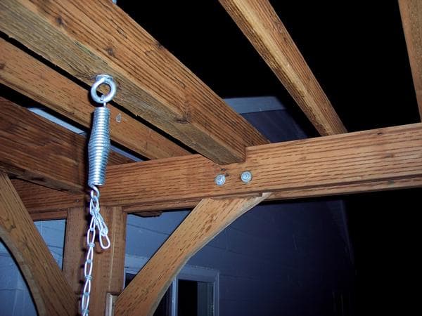 The swing is held up by eye bolts. Alternately, the swing manufacturer supplied lag screws with a nice quiet plastic hinge. Had I known they were going to be included, I would have saved drilling and installing the eye-bolts (live and learn)!