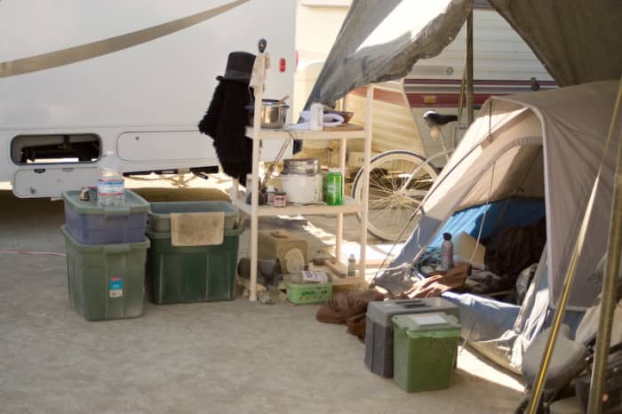 A nice set up. Tent under a shade structure with all supplies in storage bins to keep them handy and clean. Other items are handy on a shelf.