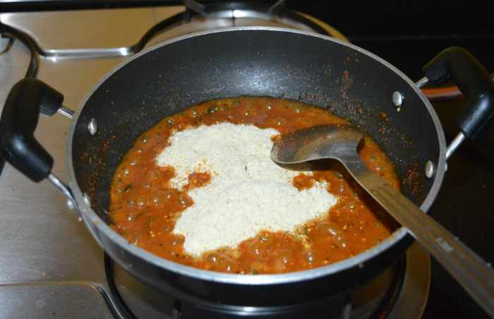 Reduce the heat. Add the sesame seeds and fried gram powder. Mix well.