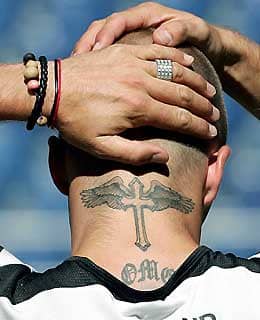The winged cross on the neck of soccer star David Beckham. His back is tattooed with a large cross and his right upper arm has a large tattoo of an angel on it.