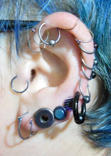 An ear full of tunnel and plug piercings: 2g tunnel, 4g titanium plug, 2g plastic plug