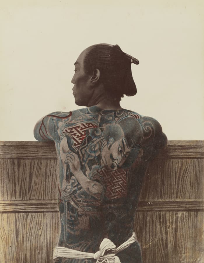 A photograph by Kusakabe Kimbei taken between 1870 and 1899 of a tattooed Japanese man. In Japan and China, tattoos were considered to be a spiritual enhancement.