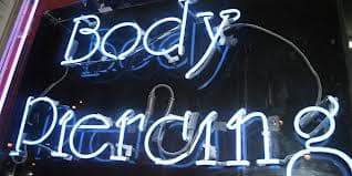 Most tattoo shops that offer piercings will have a sign displayed such as this.