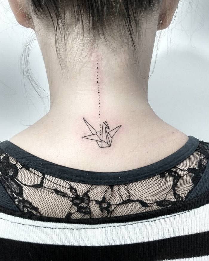 Ein Tattoo eines Origami-Kranichs im Nacken.