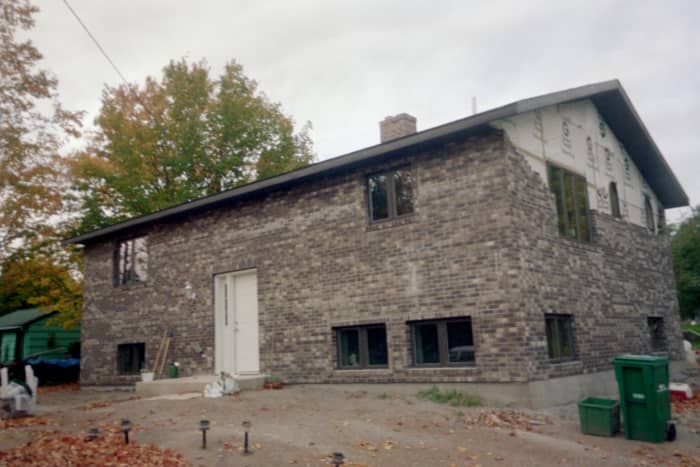 A brick house being built in the neighborhood. A neighborhood is a street, an apartment complex or other area where people live. The people make it a neighborhood.
