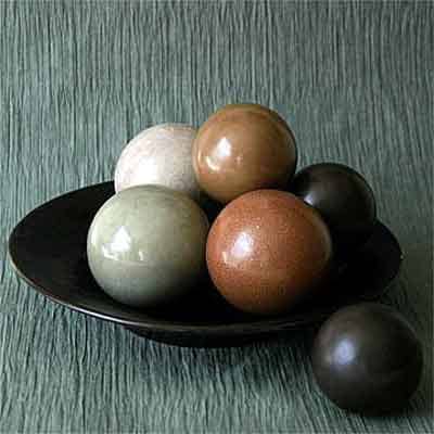 The color of the finished dirt balls comes from the color of the dust or clay used to coat the outside layers of the tightly-compressed ball of mud.