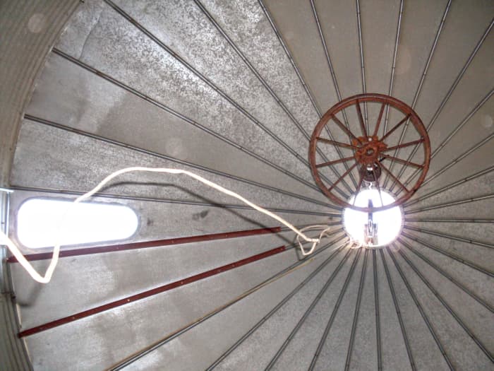 There's something magical about staring up at the roof of a grain bin . . . almost like a cathedral. That's the lifting ring in the center, almost like a chandelier—an old truck rim, a bit bigger than the hole.