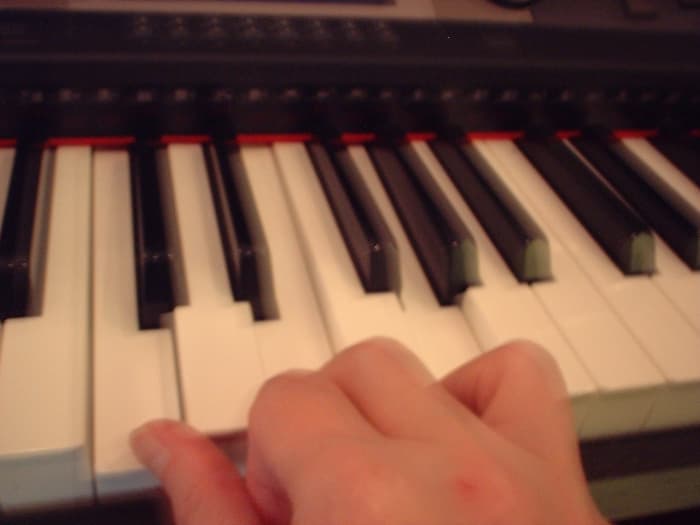 This hand is pulled back to show which keys are being played. It's not intended as an example of a good hand position at all!