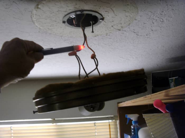 Prueba de cables "calientes" con un detector de voltaje al cambiar una lámpara."hot" wires with a voltage detector when changing a light fixture.