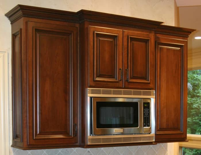 Microwave oven with cabinets above and on both sides.