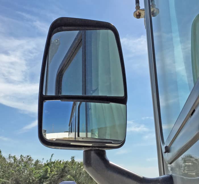 Standard motorhome mirrors are mounted at the front of the RV and are designed to give a both distant and close-up view of the road behind the RV