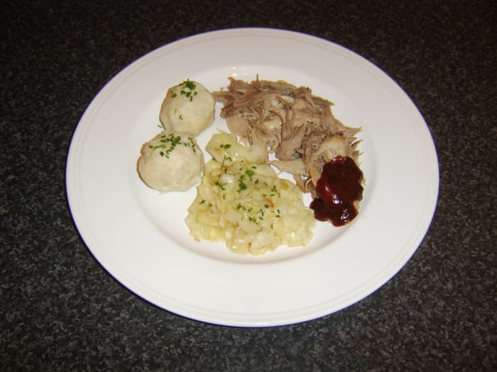 Pulled pork is taken from the popular Bavarian cut of pork that is the shank or knuckle and served with authentic German potato dumplings and braised cabbage instead of sauerkraut