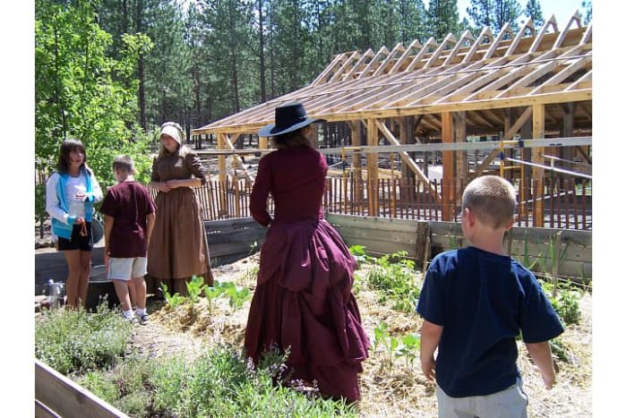 Museum volunteers in period dress show children what its like to pump water and tend to crops at the High Desert Museum (c) Stephanie Hicks