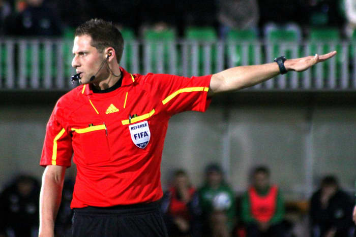 When the ref holds their hand horizontally and points forward, it signals a direct free kick or a new start from the center of the field.