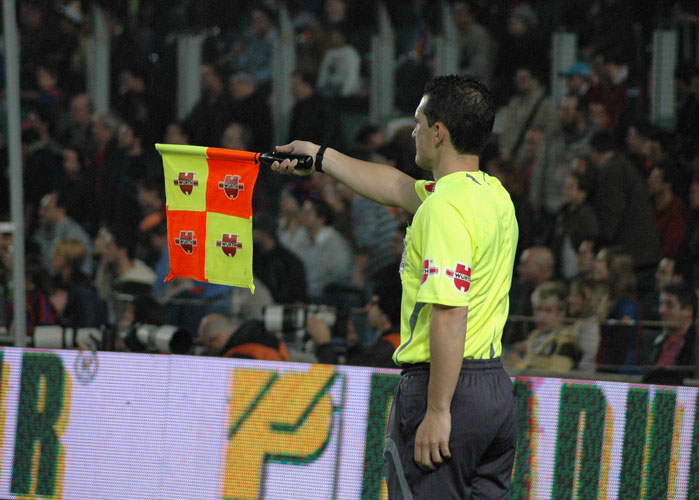 The assistant ref will point with the flag to show which direction to play the ball after it goes out.