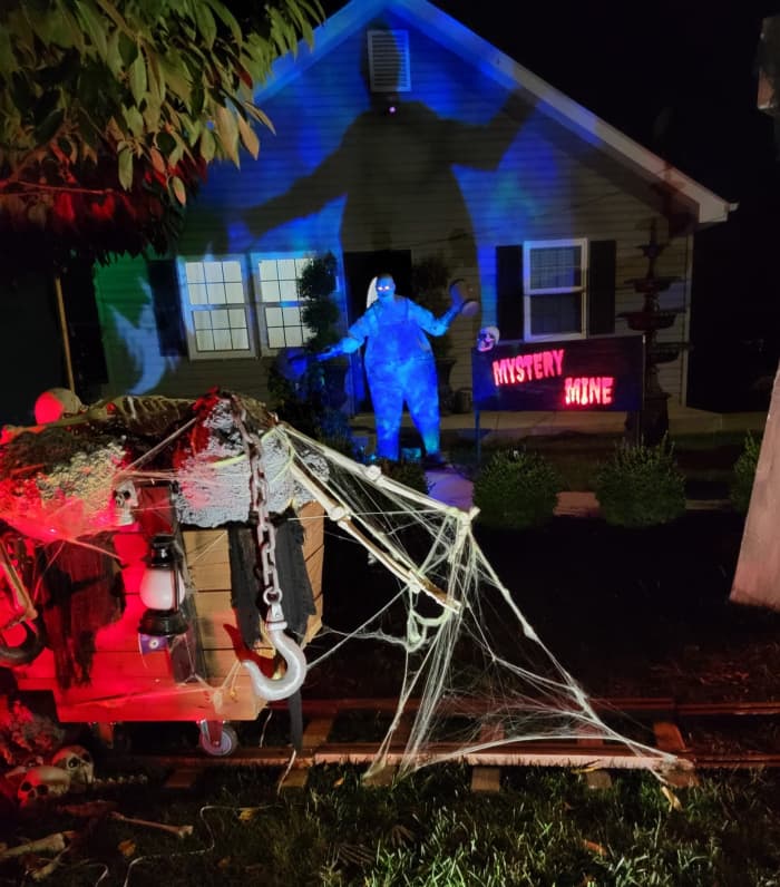 Some friends decorated their yard with a spooky mine scene complete with railroad tracks, a mine shaft, and a creepy character with a chainsaw.