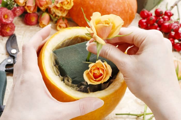 Hull out small pumpkins. Using craft foam, poke fall-colored flowers inside to create a beautiful arrangement.