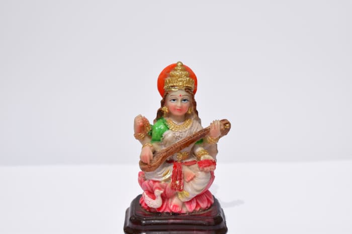 An idol of godess Saraswati holding a harp in hands.