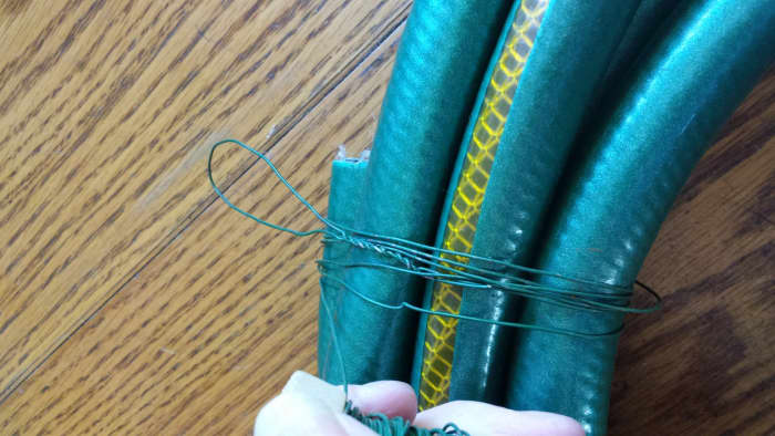 A hose makes a heavy base, so be sure to wrap enough wire that it will hold the weight of your finished wreath, hold the shape, and hold it together.