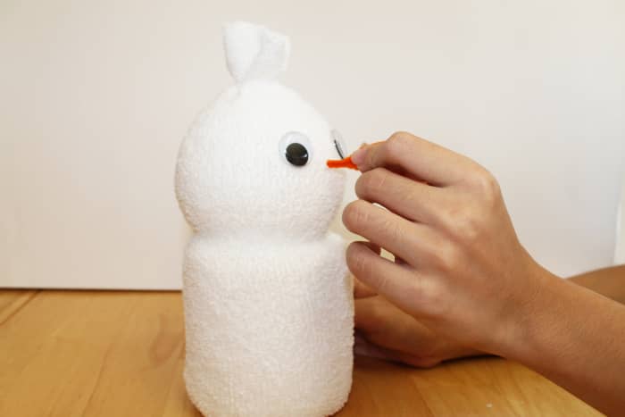 To attach the nose, push the chenille stem through the sock and into the styrofoam ball until it feels secure.