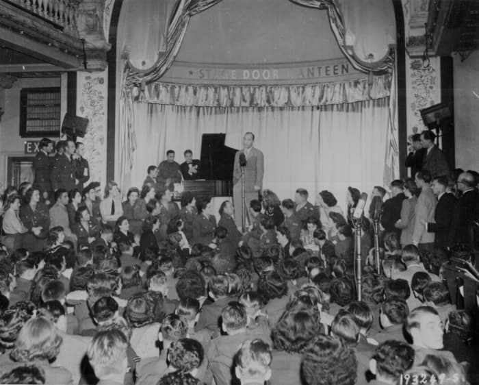 Bing Crosby sings for Allied troops at the opening of the stage door canteen in Piccadilly, London, England." Pearson, August 31, 1944.