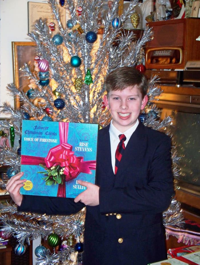Grantley Waters Showing his Firestone Presents Your Christmas Favorites Volume One, featuring Brian Sullivan, Risë Stevens, and The Firestone Orchestra and Chorus.
