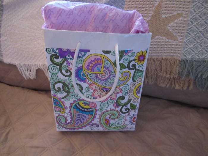 This is a simple white dollar store bag covered with a coloring page using double sided tape as adhesive