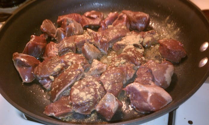 The venison cubes called for in this recipe are the trimmed and cubed meat from the hind-quarters of the deer. Here they are sprinkled with cumin before stirring to coat.