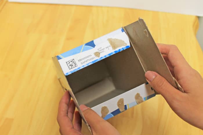 You can gently pull apart the glued sections of the tissue box. It is much easier to make your cuts when the box is laid out flat.