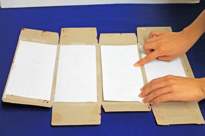 Tape the pictures you have cut out to the inside of the box. Make sure that they are all facing the same way.