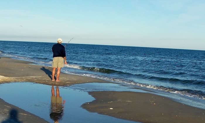 A lone fisherman surf fishes on St. George Island State Park beach. In the winter, the beaches are deserted except for a few fishermen and some Great Blue Herons who stalk them hoping for a handout.