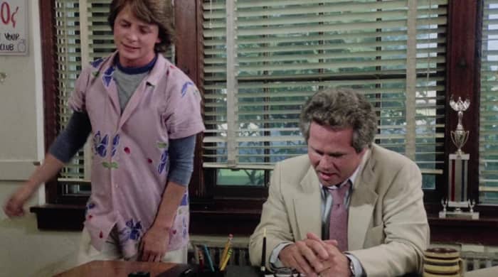 Jay-Jay Manners (Michael J. Fox) gets ready to take his punishment from Principal Kinney (Tony Dow) on the first day of school