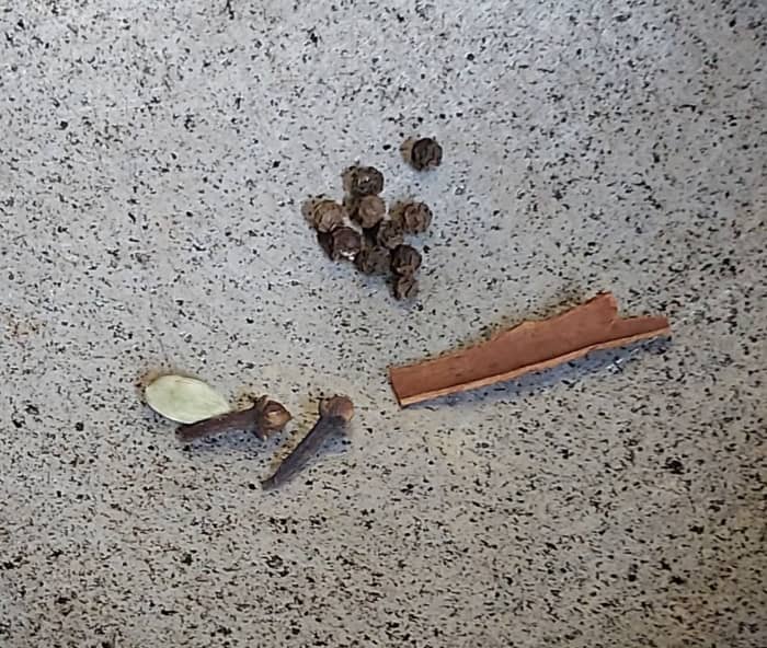 In a frying pan take 1 inch long cinnamon, 6-7 black pepper, 2-3 cloves and 1-2 cardamom. Fry for a minute in medium flame. Switch off the flame.