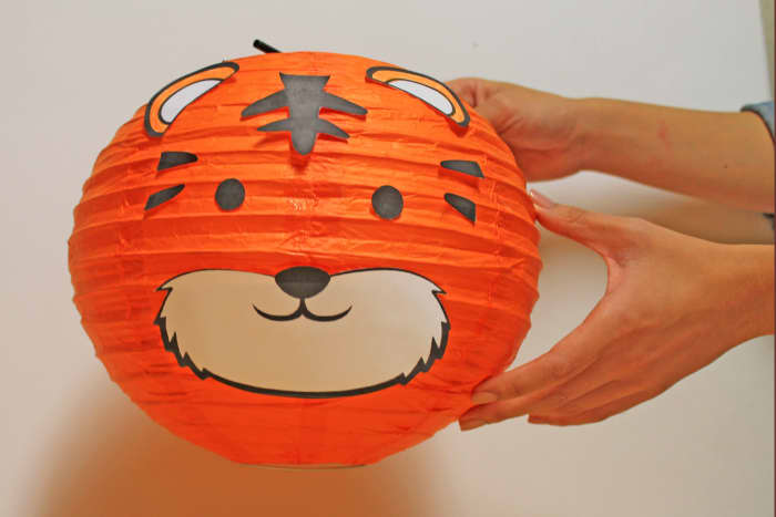 For this lantern, start with a purchased orange paper lantern. Then, print out the template which has the facial features you can affix to the lantern.