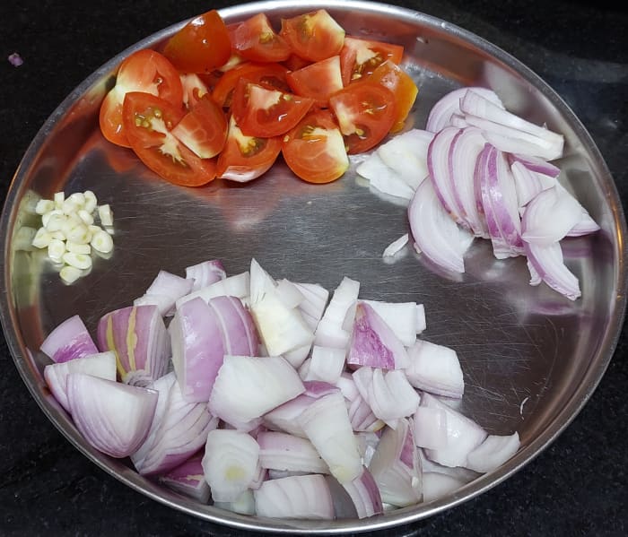 Roughly chop 1 1/2 onions and 2 tomatoes. Chop 1/2 onion lengthwise. Finely chop 3-4 garlic cloves. Set aside.