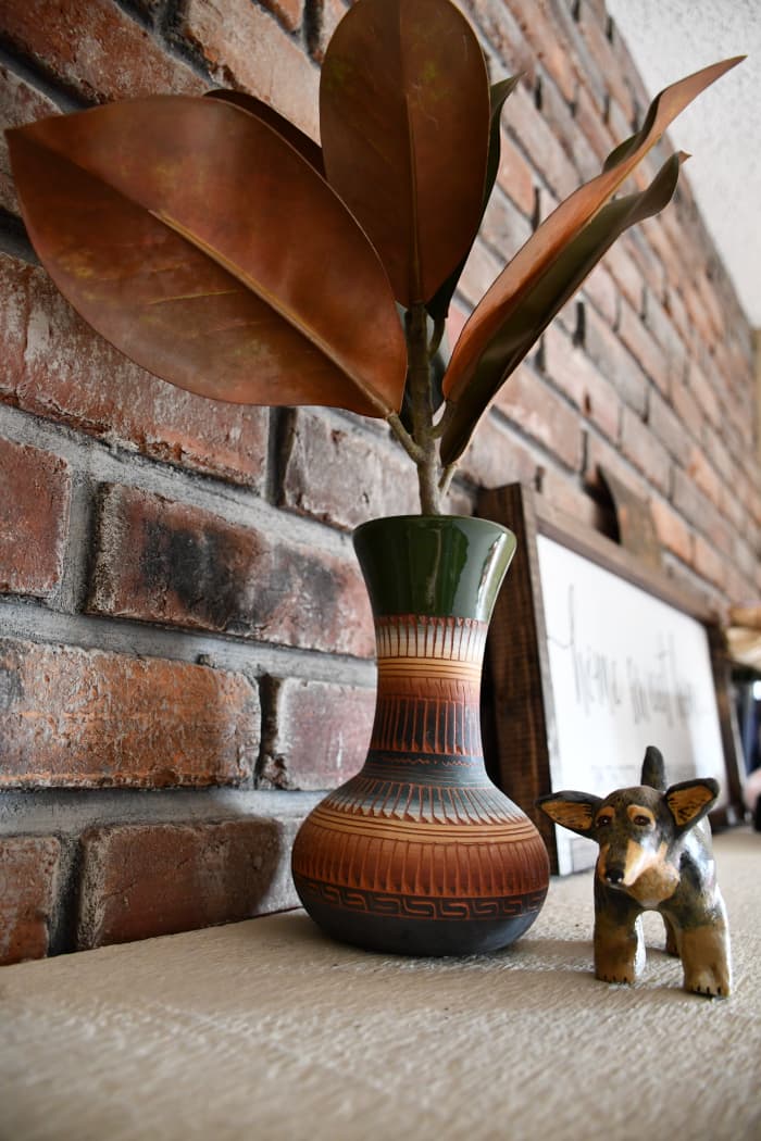 The fall leaves arrangement is mostly brown and green. It's an unassuming piece that helps bring things together. It simultaneously brings maturity and whimsy into a room.