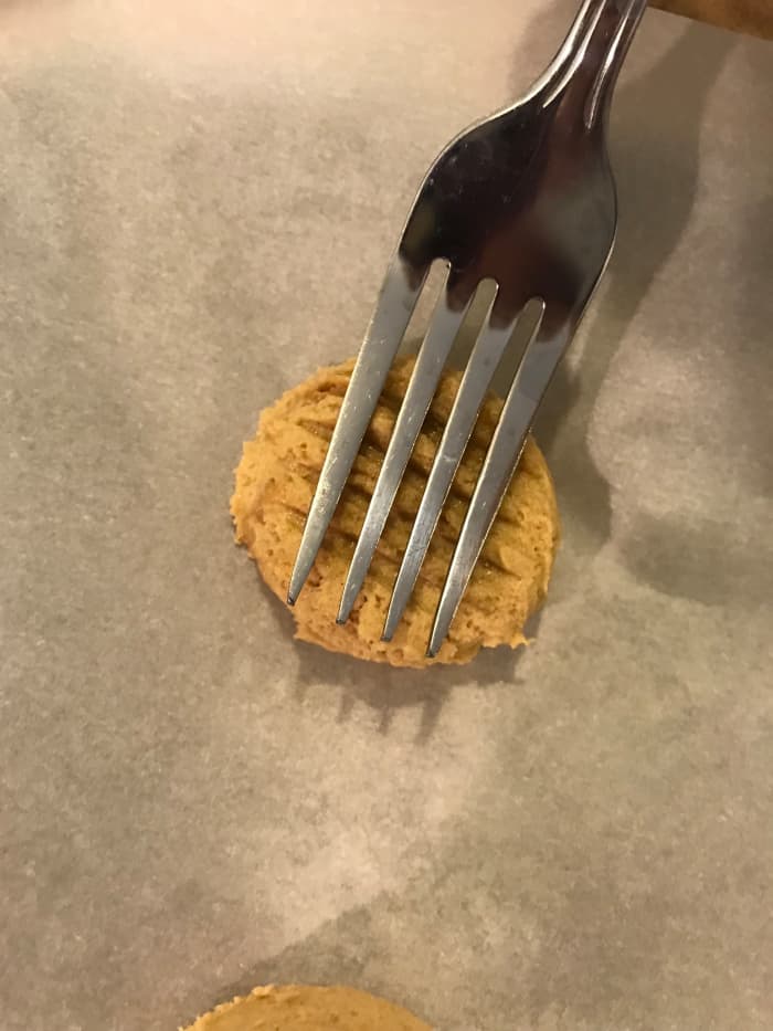 Gently press the tines of a fork into the top of the cookie, then turn and press it cross-wise. This makes the traditional checkered pattern on the top of the finished cookies.