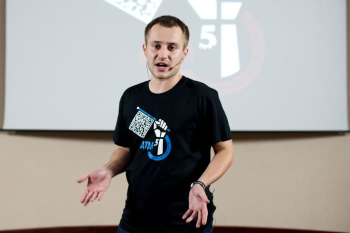 Man speaking in front of a live audience.