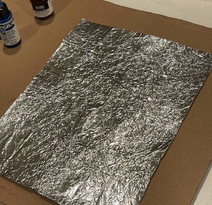 Open up the foil ad gently press on it to make it flat. It will retain a texture created by the crumpling.
